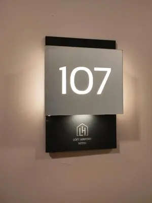 a sign on a wall with a light on it at Loft Airport Hotel in Arnavutköy