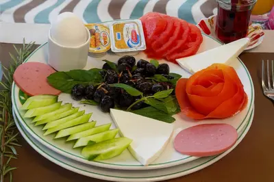a plate of cheese and vegetables on a table at Loft Airport Hotel in Arnavutköy