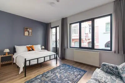 a bedroom with a bed and a large window at Modern and Cozy 2BR in Vibrant Cihangir in Istanbul