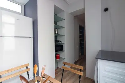 a kitchen with a refrigerator and a table and chairs at Modern and Cozy 2BR in Vibrant Cihangir in Istanbul