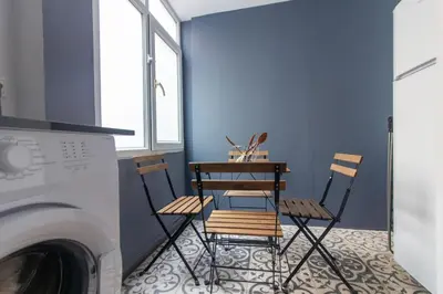 two chairs and a table in a room with a washing machine at Modern and Cozy 2BR in Vibrant Cihangir in Istanbul