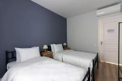 two beds in a room with blue walls at Modern and Cozy 2BR in Vibrant Cihangir in Istanbul