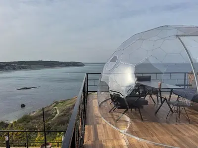 a tent with a table and chairs on a deck overlooking the water at Marina Boutique Hotel Istanbul Airport in Karaburun