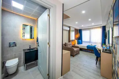a bathroom with a toilet and a living room at Cosinüs Airport Hotel in Arnavutköy