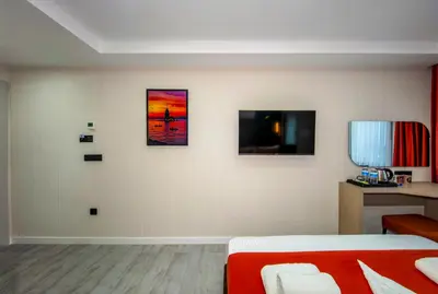 a bedroom with a bed and three pictures on the wall at Cosinüs Airport Hotel in Arnavutköy