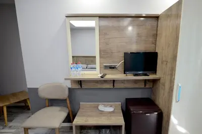 a room with a desk with a television and a table at Tüm Palace Otel in Bandırma