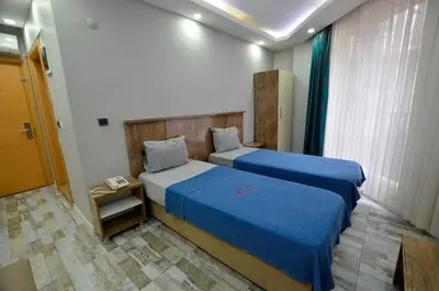 a hotel room with two beds and a window at Tüm Palace Otel in Bandırma