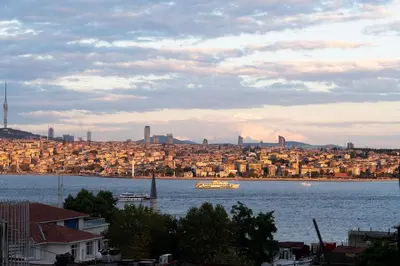 a boat in a large body of water with a city at Luxury with Exceptional Terrace and Bosphorus View in Istanbul