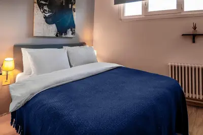 a bedroom with a large bed with a blue blanket at Luxury with Exceptional Terrace and Bosphorus View in Istanbul
