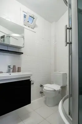 a white bathroom with a toilet and a sink at Luxury with Exceptional Terrace and Bosphorus View in Istanbul