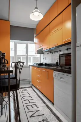 a kitchen with orange cabinets and a table with chairs at Luxury with Exceptional Terrace and Bosphorus View in Istanbul