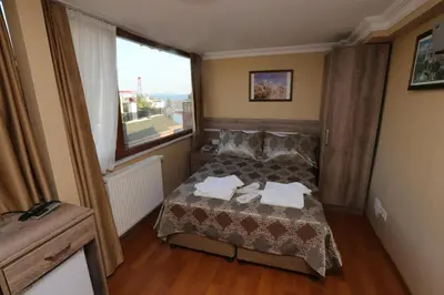 a small bedroom with a bed and a large window at My Holiday Time Hotel in Istanbul
