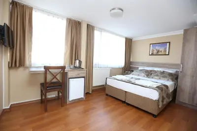 a bedroom with a bed and a desk and windows at My Holiday Time Hotel in Istanbul