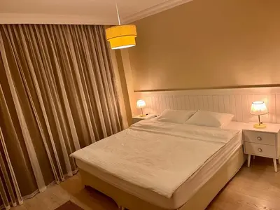 a bedroom with a large bed and two lamps and a window at Next to Cevahir Shopping Mall Perfect location comfortable luxury apartment in Istanbul