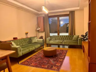 a living room with two green couches and a rug at Next to Cevahir Shopping Mall Perfect location comfortable luxury apartment in Istanbul