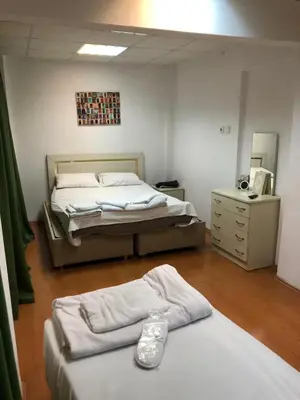 a bedroom with two beds and a dresser and a mirror at Bahar 5 in Istanbul