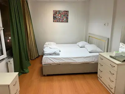 a small bedroom with two beds and green curtains at Bahar 5 in Istanbul