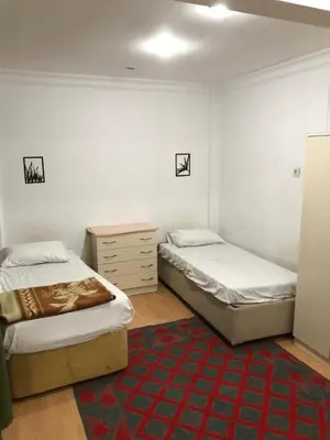 a bedroom with two beds and a dresser and a rug at Bahar 5 in Istanbul
