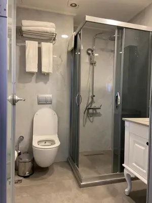 a bathroom with a toilet and a glass shower at Istanbul Town Hotel in Istanbul