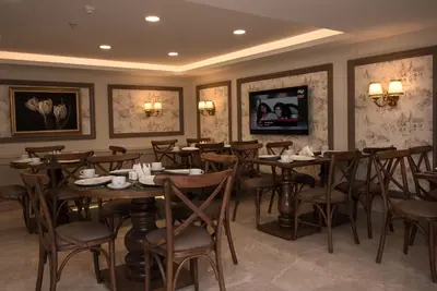 a restaurant with tables and chairs and a tv at Istanbul Town Hotel in Istanbul