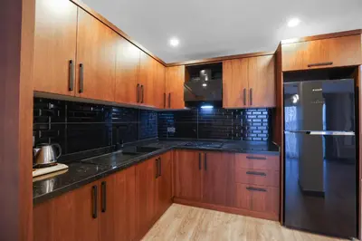a kitchen with wooden cabinets and a stainless steel refrigerator at Best Western Plus Sapanca in Sapanca