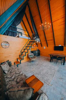 a living room with a couch and a table and stairs at Bungorise Bungalov in Sapanca
