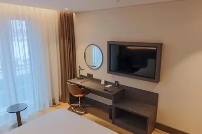 a hotel room with a desk and a television on the wall at Ramada by Wyndham Arnavutkoy in Istanbul
