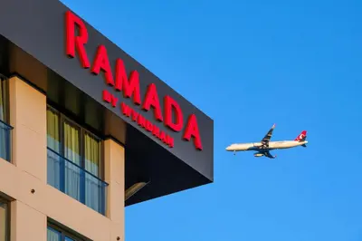 a plane flying over a building with a ryanair sign at Ramada by Wyndham Arnavutkoy in Istanbul