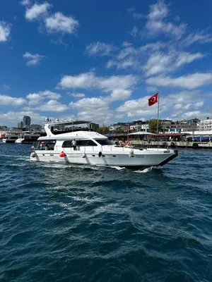 a white boat in the water with a red flag at Private Luxury Bosphorus Yacht 2 Continents Experience in Istanbul