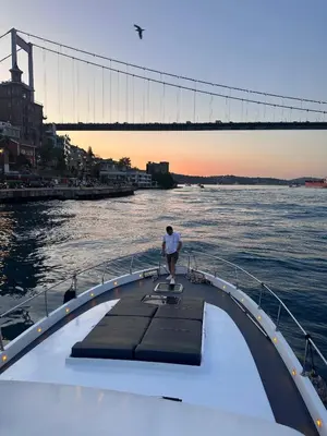a man standing on the end of a boat in the water at Private Luxury Bosphorus Yacht 2 Continents Experience in Istanbul