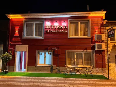 a red building with two chairs in front of it at Mütena konaklama in Mudanya