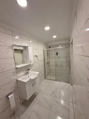 a white bathroom with a sink and a shower at Mütena konaklama in Mudanya