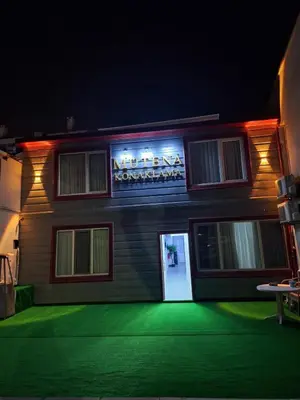 a building with a sign on the side of it at night at Mütena konaklama in Mudanya