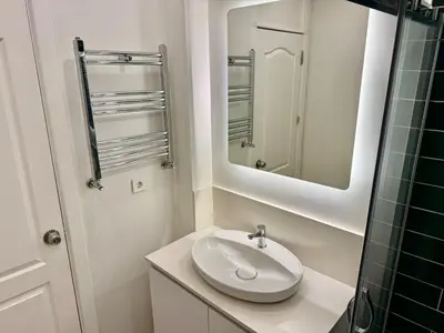 a white bathroom with a sink and a mirror at Nisantasi - Spacious and Modern Loft House in Istanbul