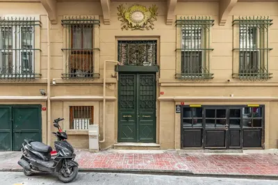 a scooter parked in front of a building with green doors at Ganbaru Tours - Flats in Galata 2 in Istanbul