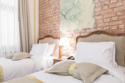 two beds in a room with a brick wall at Hotel Pera Parma in Istanbul