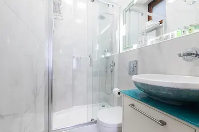 a bathroom with a sink and a glass shower at Hotel Pera Parma in Istanbul