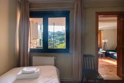 a bedroom with a bed with a window and a chair at Leafy Views & Light Filled Comfort in Kuzguncuk in Istanbul