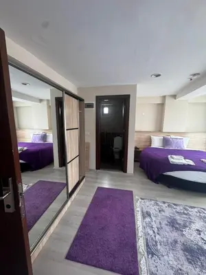 a bedroom with two purple beds and purple rugs at grand life hotel in Corlu