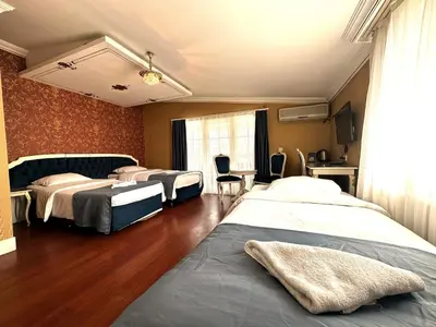 a hotel room with three beds and a window at Hotel Alyon Beyoğlu in Istanbul