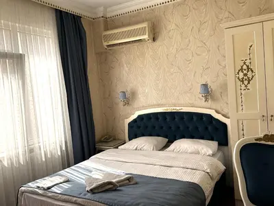 a bed with a blue headboard in a bedroom at Hotel Alyon Beyoğlu in Istanbul