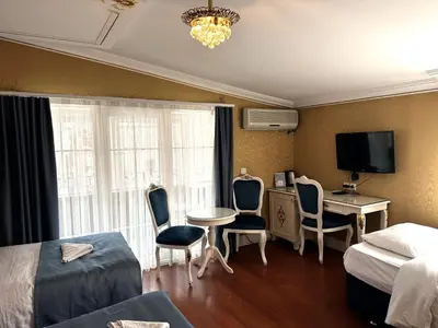 a hotel room with a bed and a table and chairs at Hotel Alyon Beyoğlu in Istanbul