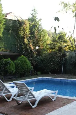 two white chairs sitting next to a swimming pool at Detached villa with a heated pool and garden in Sapanca
