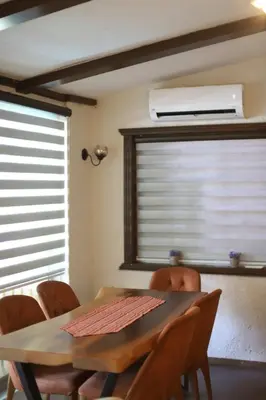 a dining room with a wooden table and chairs at Detached villa with a heated pool and garden in Sapanca