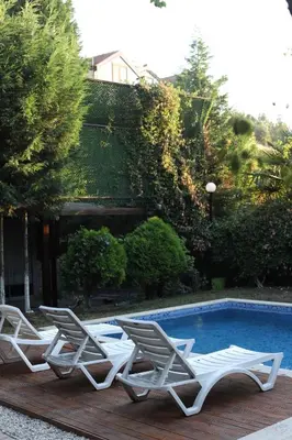 a group of lounge chairs and a swimming pool at Detached villa with a heated pool and garden in Sapanca