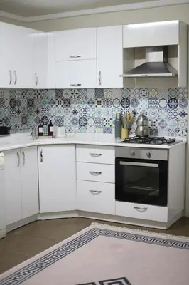 a kitchen with white cabinets and a black oven at Detached villa with a heated pool and garden in Sapanca