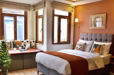 a bedroom with a large bed with windows and a christmas tree at PeraHomes DE in Istanbul