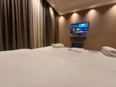 a bedroom with a white bed with a flat screen tv at Riddim apartment in Istanbul