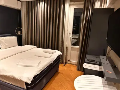 a bedroom with a bed and a desk and a window at Riddim apartment in Istanbul