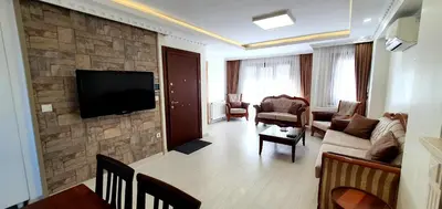 a living room with a flat screen tv on a stone wall at Taksim Flat in Istanbul